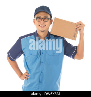 Delivery person delivering package smiling happy in blue uniform. Handsome young Asian man professional courier isolated on white background. Stock Photo