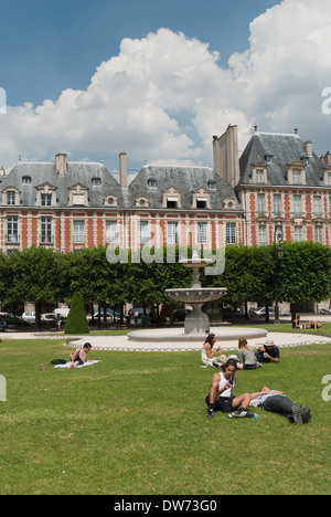 People picnic on the lawn in the Place des Voges in Paris, France. Stock Photo