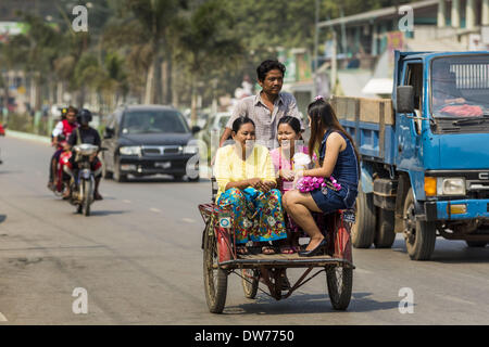 March 2, 2014 - Myawaddy, Kayin, Myanmar - A pedicab driver takes women in Myawaddy, Myanmar. Pedicabs are still used in much of Myanmar (Burma). Myawaddy is separated from the Thai border town of Mae Sot by the Moei River. Myawaddy is the most important trading point between Myanmar and Thailand. (Credit Image: © Jack Kurtz/ZUMAPRESS.com) Stock Photo