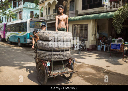 March 2, 2014 - Myawaddy, Kayin, Myanmar - A tire seller drives his pedicab loaded with commercial truck tires in Myawaddy, Myanmar. Myawaddy is separated from the Thai border town of Mae Sot by the Moei River. Myawaddy is the most important trading point between Myanmar (Burma) and Thailand. (Credit Image: © Jack Kurtz/ZUMAPRESS.com) Stock Photo