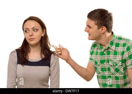 Young man arguing with his girlfriend pointing his finger at her as she turns aside in indifference, isolated on white Stock Photo