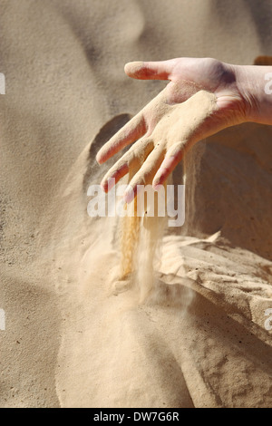 Sand slipping through the fingers of a woman's hand in the desert of Sahara in Tunisia. Stock Photo