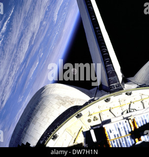 Earth and its Moon, framed in this image taken from the aft windows of the Space Shuttle Discovery Stock Photo
