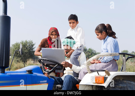 Indian farmer driving tractor with his family Stock Photo