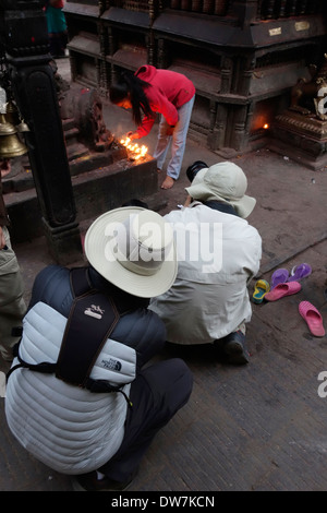 Photographers taking pictures of worshipers lighting candles at Swayambhunath,  the Monkey Temple, Kathmandu, Nepal. Stock Photo