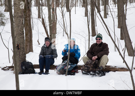 Winter hikers relax and rest along a snow-covered trail on Mount Greylock, Adams, MA. Stock Photo