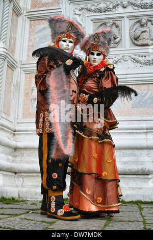 Participants in orange and brown costumes at Venice Carnival, Italy, 2014 Stock Photo