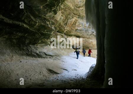 Starved Rock State Park, Illinois, USA. 2nd March 2014. Hikers in LaSalle Canyon framed by a frozen waterfall and canyon walls. Sadly, someone has defaced the rock in this picturesque area southwest of Chicago. Credit:  Todd Bannor/Alamy Live News Stock Photo