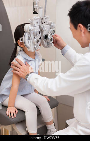 Doctor examining girl's eyes Stock Photo