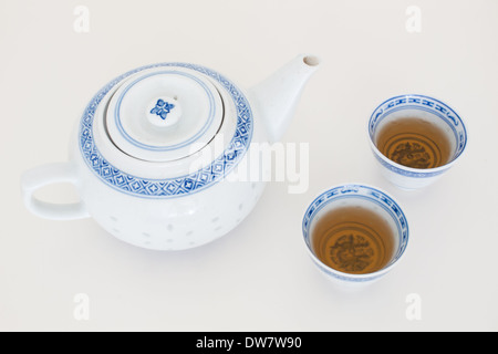A traditional Chinese teapot and teacups filled with jasmine green tea. Stock Photo
