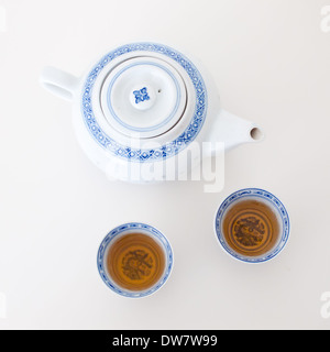 A traditional Chinese teapot and teacups filled with jasmine green tea. Stock Photo