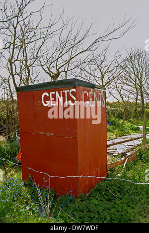 an old hut being used as a gents toilet on a wild camp site Stock Photo