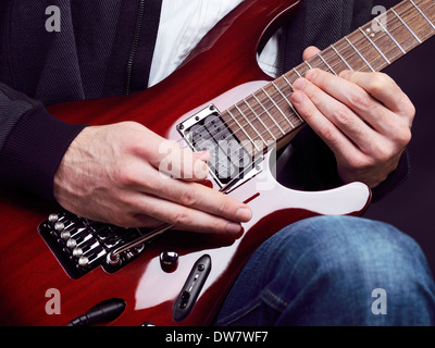 License and prints at MaximImages.com - Closeup of man hands playing red electric guitar Ibanez Stock Photo