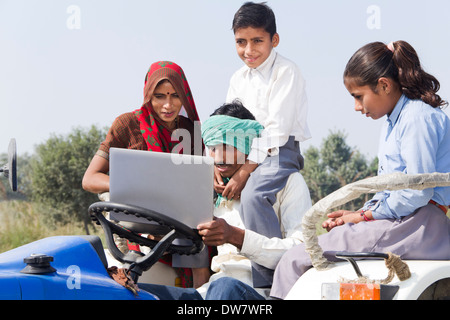 Indian farmer driving tractor with his family Stock Photo