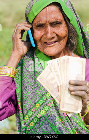 1 Indian woman standing and talking with mobile Stock Photo