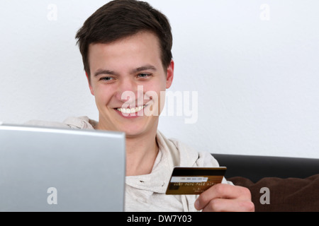 A young man is using his laptop computer for internet shopping Stock Photo