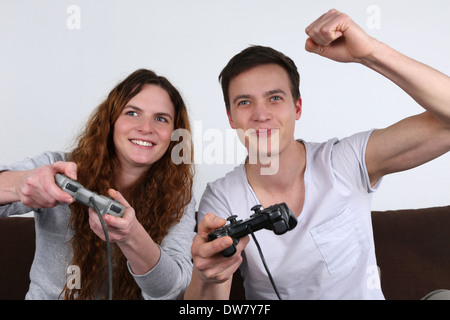 Two young people having fun while playing video games Stock Photo