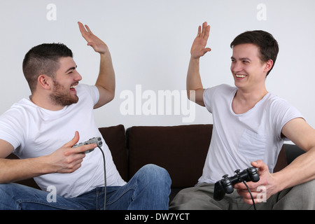 Two young men winning and having fun while playing video games Stock Photo