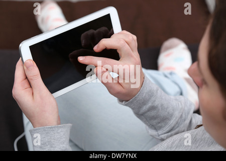 A young woman is using her tablet computer with a finger Stock Photo