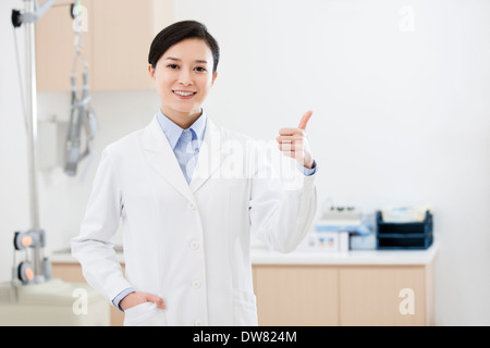 Happy female doctor doing thumbs-up Stock Photo