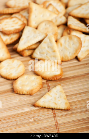 Stack of different shaped salty cracker biscuits on bamboo background Stock Photo