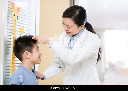 Doctor measuring boy's height Stock Photo