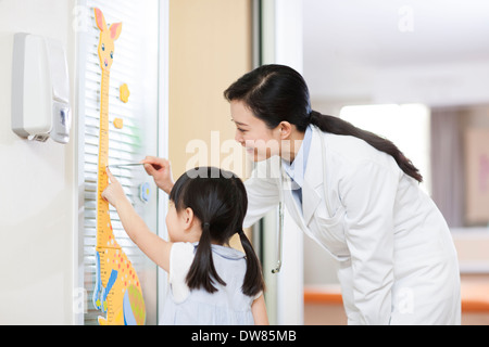 Doctor measuring girl's height Stock Photo