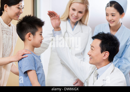 Doctor talking to little boy in hospital Stock Photo