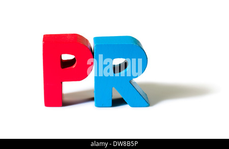 Multicolored text PR made of wood. White background Stock Photo