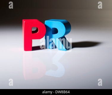 Multicolored text PR made of wood. White background Stock Photo