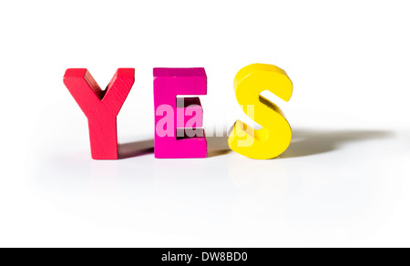 Multicolored text yes made of wood. White background Stock Photo