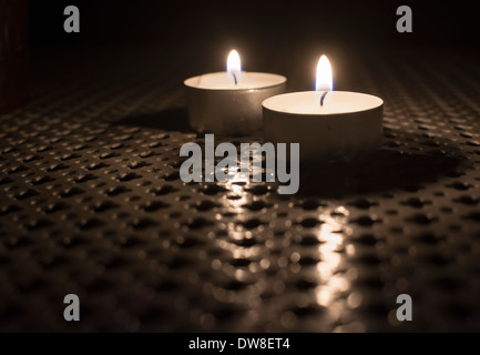 Two Tealights on outdoor table in the dark. Stock Photo