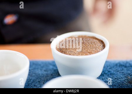 An El Salvadoran coffee producer cups a fresh grind and pour of his beans at his roasting facility in Juayua El Salvador Stock Photo