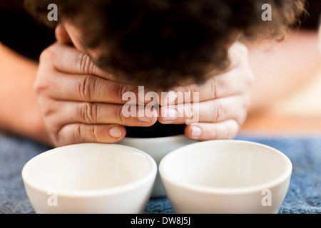 An El Salvadoran coffee producer cups a fresh grind and pour of his beans at his roasting facility in Juayua El Salvador Stock Photo