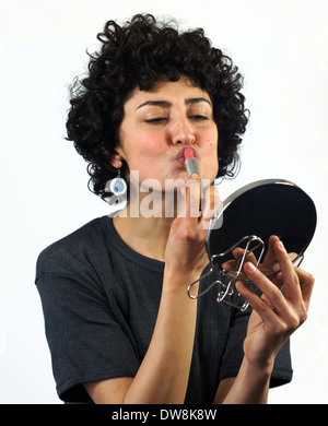 Woman putting on lipstick Stock Photo