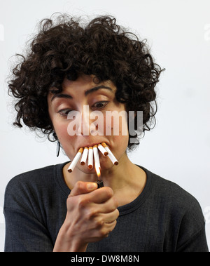 Woman lights up 5 cigarettes Stock Photo