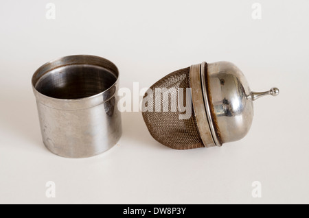 Metal tea infuser with container showing tannin stains Stock Photo