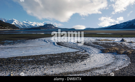 Ice patterns in winter on a beach near the Chilkat Inlet in Southeast Alaska with clouds. Stock Photo