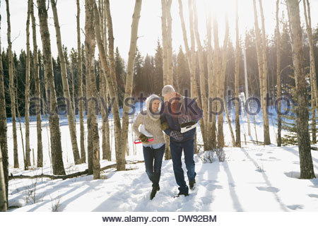 Couple walking through forest with ice skates