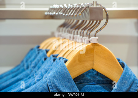 Jeans shirts on the hangers in the clothing store Stock Photo