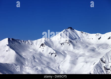 Off-piste snowy slope and blue clear sky. Caucasus Mountains, Georgia, ski resort Gudauri. Stock Photo