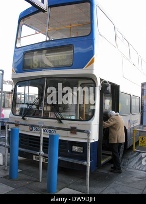 Elderly woman with a shopping trolley & people boarding a 700 Coastliner Stagecoach bus at Chichester bus station West Sussex UK Stock Photo