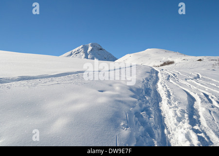 Ski touring tracks leading to the summit in winter scenic landscape. Italian western Alps. Stock Photo