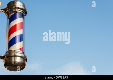 Traditional red and white barber's pole outside a hairdresser's shop. Stock Photo