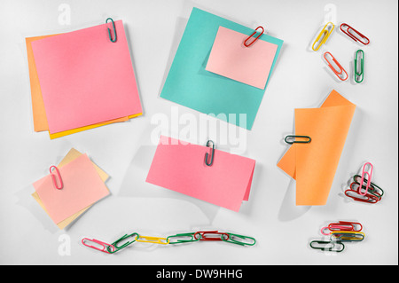 Multiple blank colorful paper notes and colorful paper clips on white background. Stock Photo