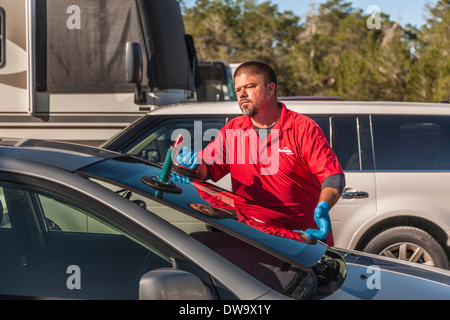 Mobile service technician replacing windshield glass on Toyota Corolla Stock Photo