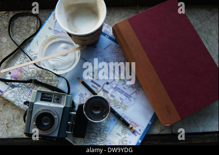 Camera, coffee and book on map Stock Photo