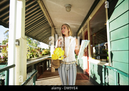 Young woman with map in verandah Stock Photo