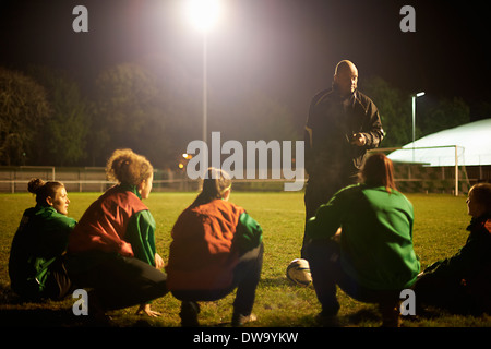 Coach briefing soccer players on field Stock Photo