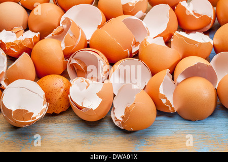 empty, broken, brown eggshells against wooden background Stock Photo